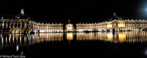 Palace de Bourse at night, reflecting in the "Mirroe" fountain.